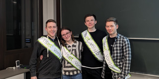 Amtsübergabe Vier Studenten stehen vor einer Tafel