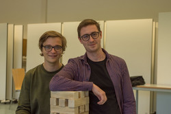 Zwei Fachschaftsmitglieder stehen an einem großen Jenga-Spiel