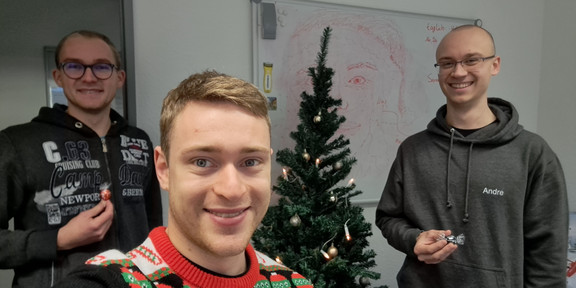 Zwei Mitarbeitende bekommen Lindor-Kugeln von einem Studenten