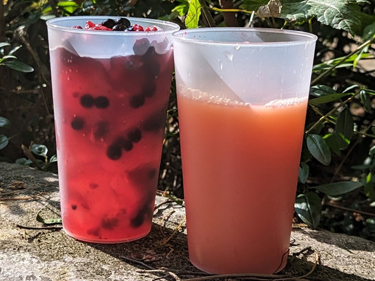 Zwei Becher mit Bowle stehen auf einer Mauer