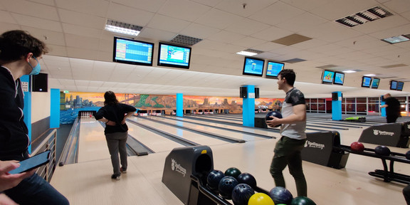 Studierende bowlen auf einer Bowlingbahn