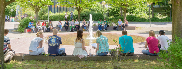 Students are sitting at the Martin Schmeisser Square in the summer