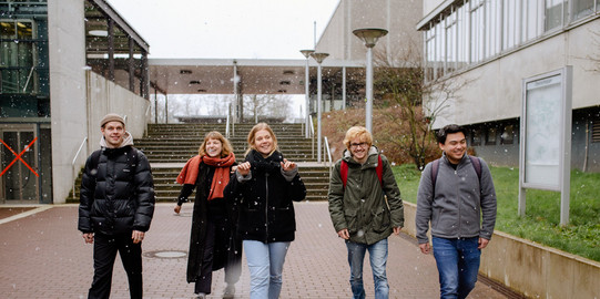 Studierende laufen über den Campus.